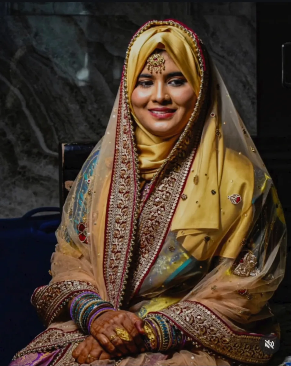 Seated bride with a veil, wedding makeup and gold jewellery