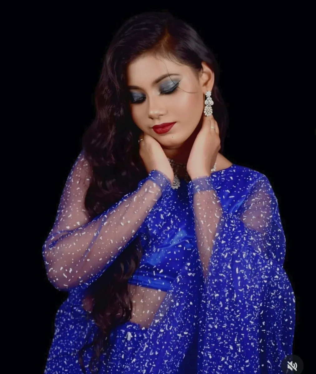 Woman in a blue gown with evening makeup and curled hairstyle