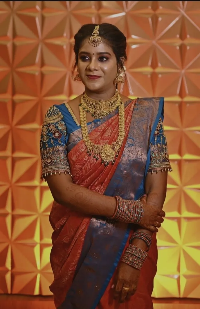 Bride in a blue and red silk saree wearing traditional wedding jewellery