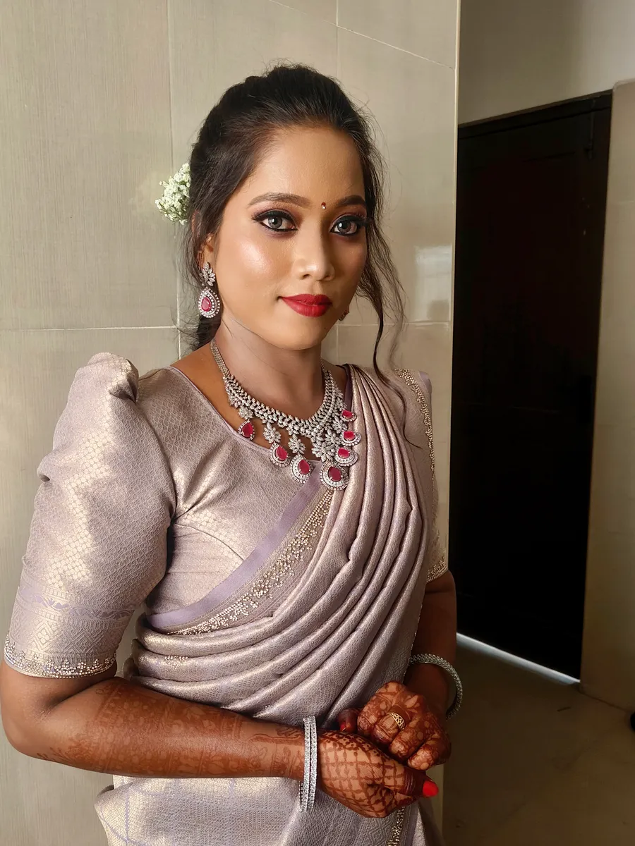 Woman in a silver saree with formal makeup and styled hair