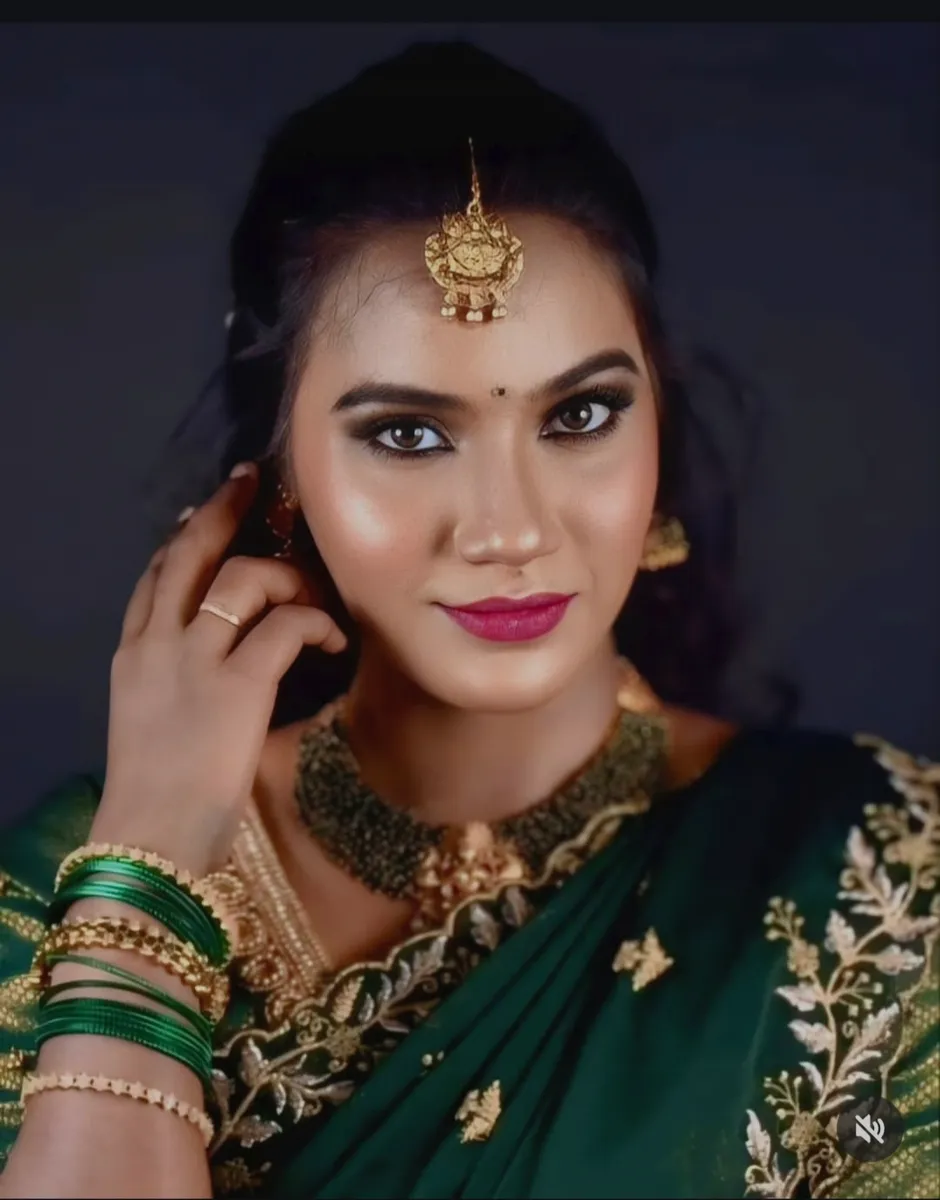 Bridal portrait in a green saree with defined eye makeup and jewellery