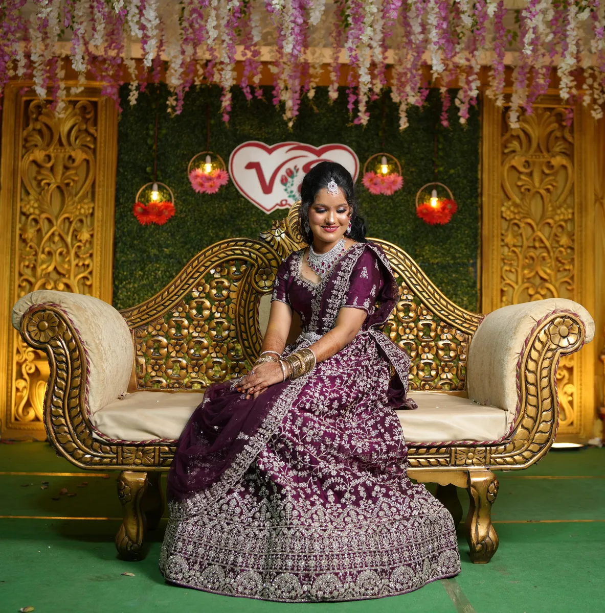 Seated bride in a purple reception gown with bridal makeup