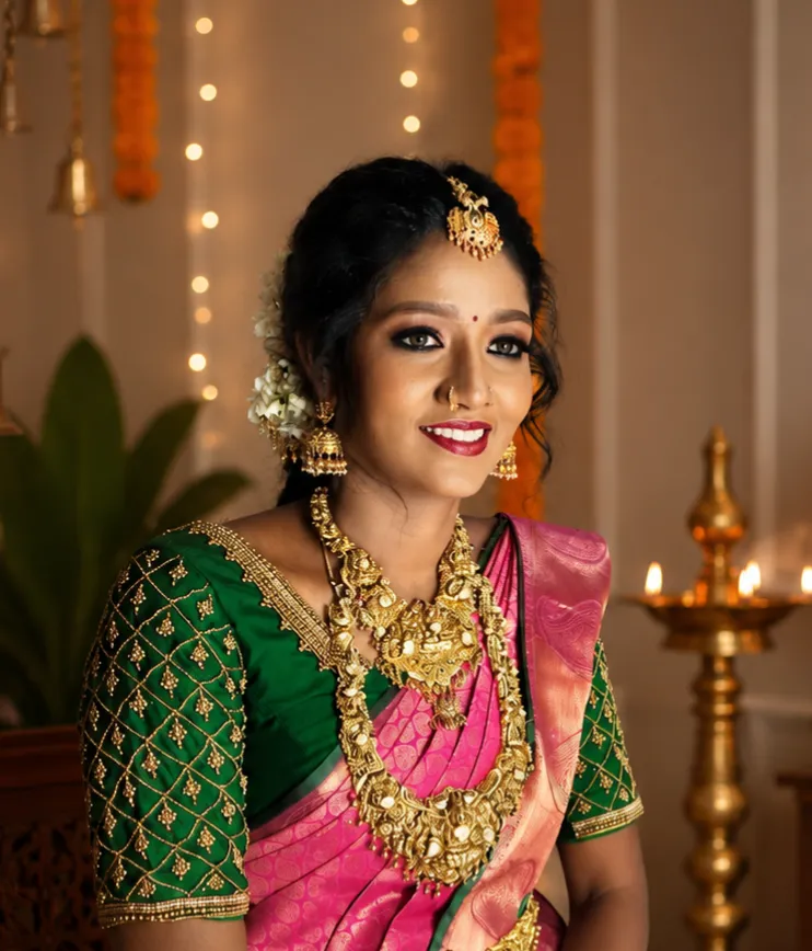 Bride in a green and pink silk saree with traditional wedding makeup